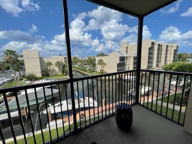 A balcony with a black metal railing overlooks a canal filled with boats and buildings — 17 Royal Palm Way # 302, Boca Raton FL 33432, BOCA RATON, FL