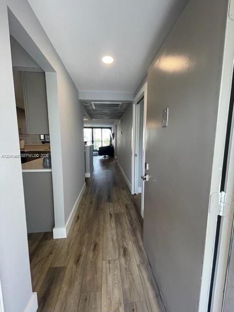 A hallway with wood-look flooring leads from an entryway toward a bright living area — 17 Royal Palm Way # 302, Boca Raton FL 33432, BOCA RATON, FL