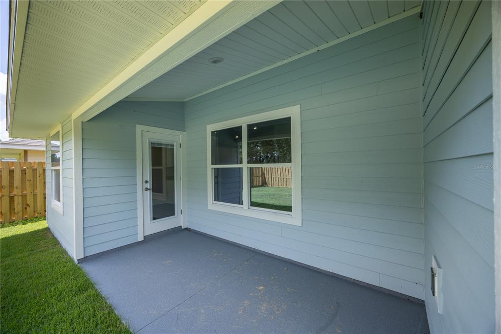 A covered patio with light blue siding, a glass door, and a window — 2602 SW 250TH TERRACE, NEWBERRY, FL