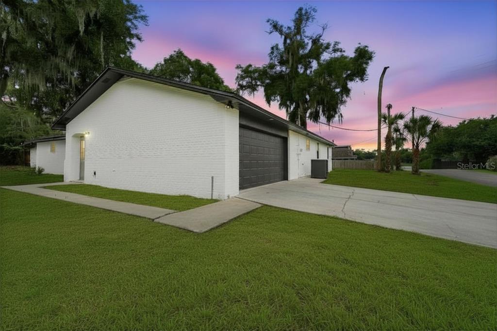 An aerial view shows a house with a black roof on a grassy lot — 107 S HIGH STREET, LAKE MARY, FL