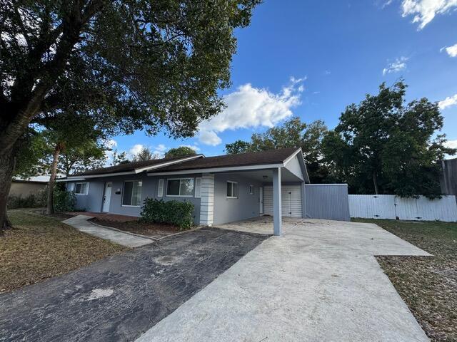 A single-story gray house with a carport and a concrete driveway under a blue sky — 1632 NW 5th Street, Boca Raton FL 33486, BOCA RATON, FL