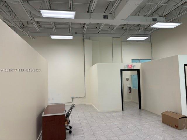 An interior view of a commercial office space with white walls, tile floors, and exposed ceilings — 13944 SW 8th St # 201, Miami FL 33184, MIAMI, FL