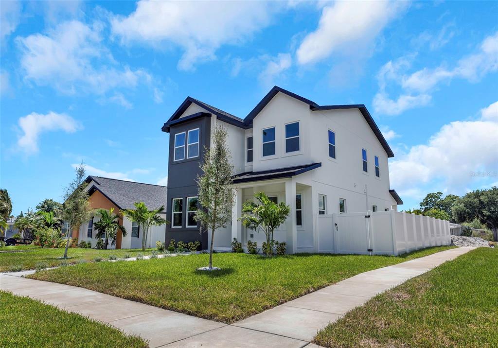 A two-story house with a white and dark gray exterior stands on a corner lot — 617 FOLSOM STREET S, ST PETERSBURG, FL