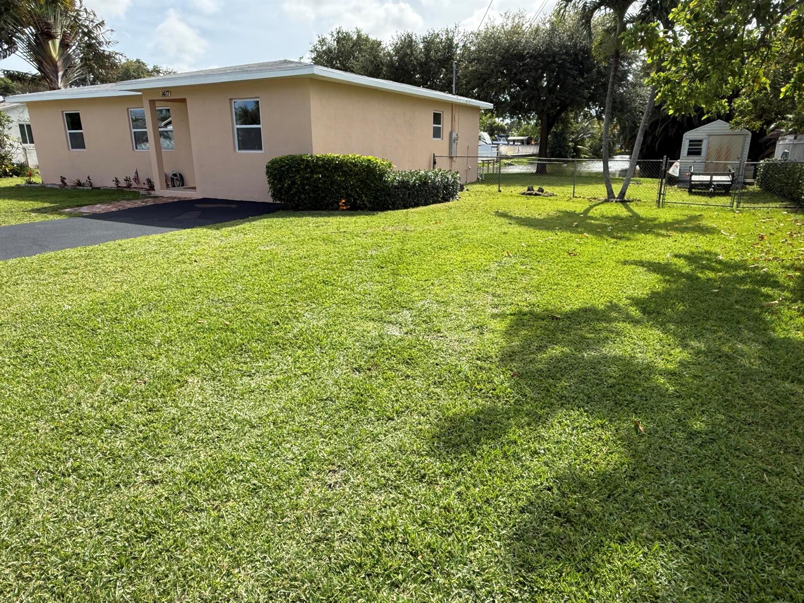 A single-story peach-colored house features a front lawn, a driveway, and a backyard shed — 1417 Willow Road, West Palm Beach FL 33406, WEST PALM BEACH, FL