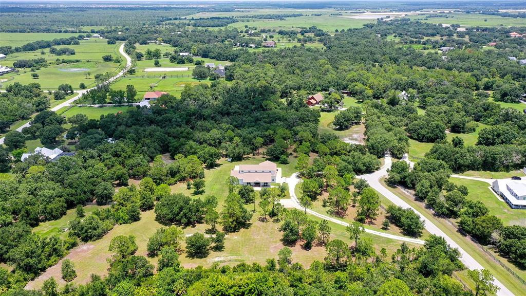 An aerial view shows a large house surrounded by trees, lawns, and a winding driveway — 1408 OAK HAMMOCK ROAD, SARASOTA, FL