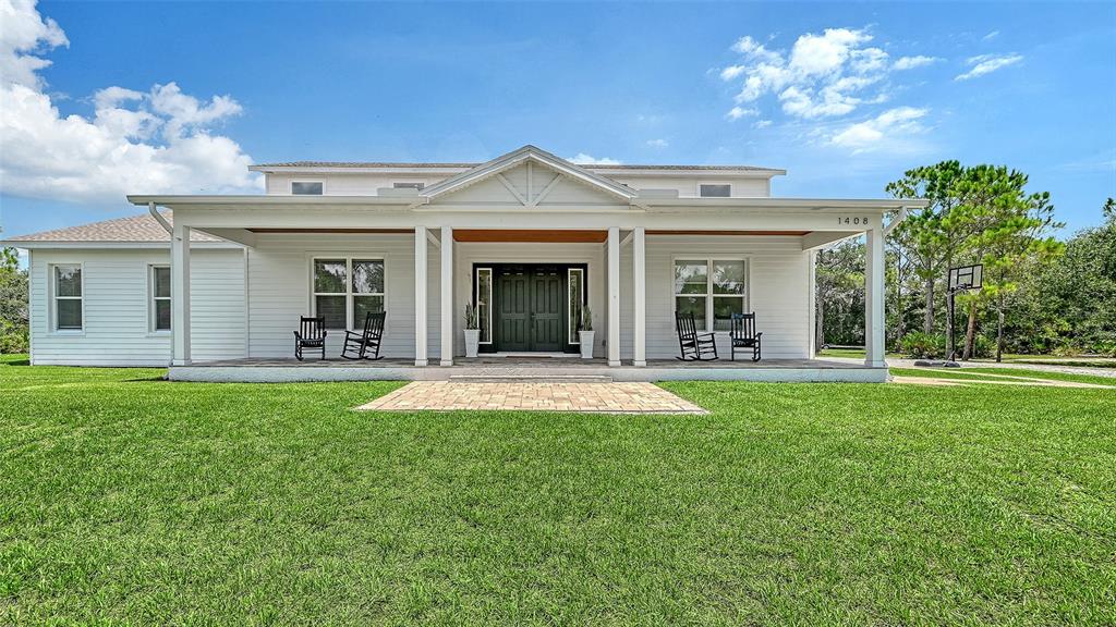A white two-story house with a large front porch and a paved walkway — 1408 OAK HAMMOCK ROAD, SARASOTA, FL