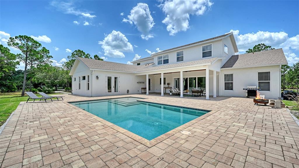 A two-story white house features a backyard swimming pool and a paved patio area — 1408 OAK HAMMOCK ROAD, SARASOTA, FL