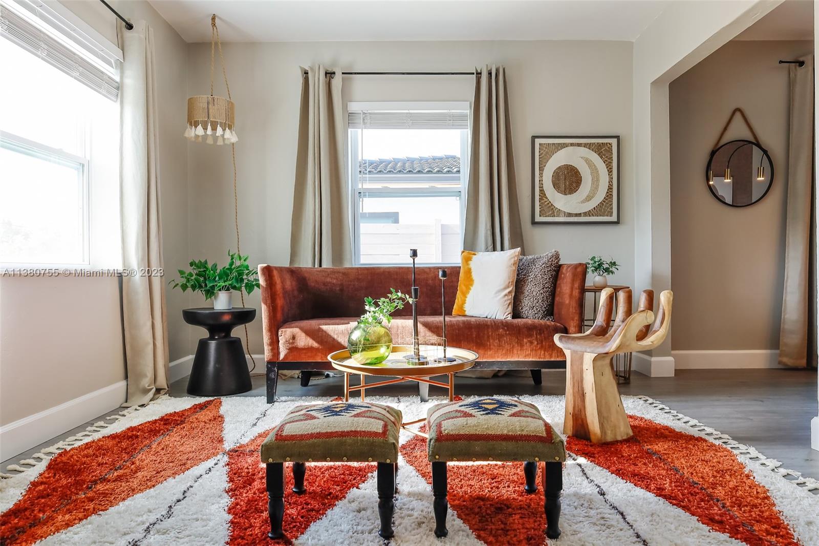 A living room features a rust-colored velvet sofa, patterned rug, and unique wooden hand chair — 2761 SW 33rd Ave # 1, Miami FL 33133, MIAMI, FL