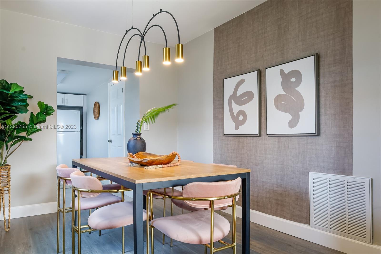 A dining room features a wooden table, pink velvet chairs, and a modern gold chandelier — 2761 SW 33rd Ave # 1, Miami FL 33133, MIAMI, FL
