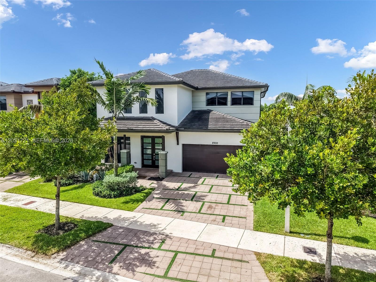 A two-story house with a tiled roof, white stucco exterior, and a paved driveway — 8900 NW 161st Ter, Miami Lakes FL 33018, MIAMI LAKES, FL