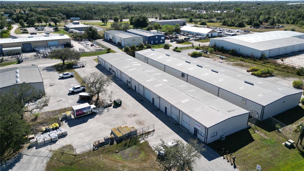 An aerial view shows several industrial warehouse buildings with metal roofs and surrounding parking lots — 5469 WILLIAMSBURG DRIVE, PUNTA GORDA, FL