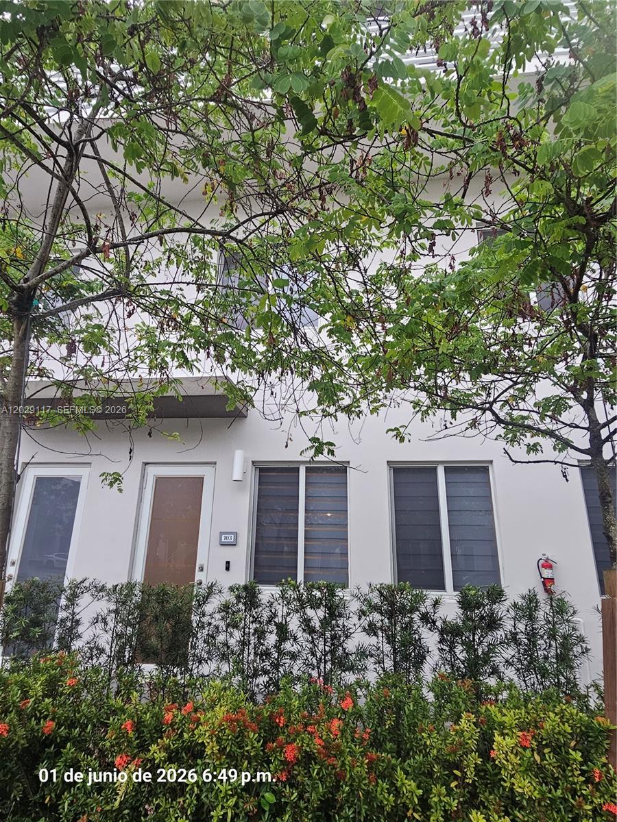 A two-story white townhouse exterior features a front door, windows, and a small hedge — 6453 NW 102nd Path # 103, Doral FL 33178, DORAL, FL