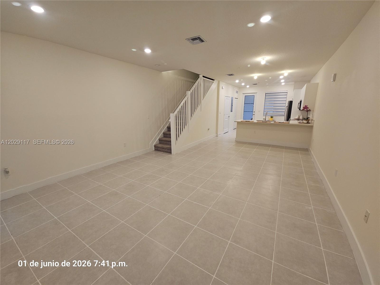 An open-concept living area features light tile flooring, a staircase, and a kitchen counter — 6453 NW 102nd Path # 103, Doral FL 33178, DORAL, FL