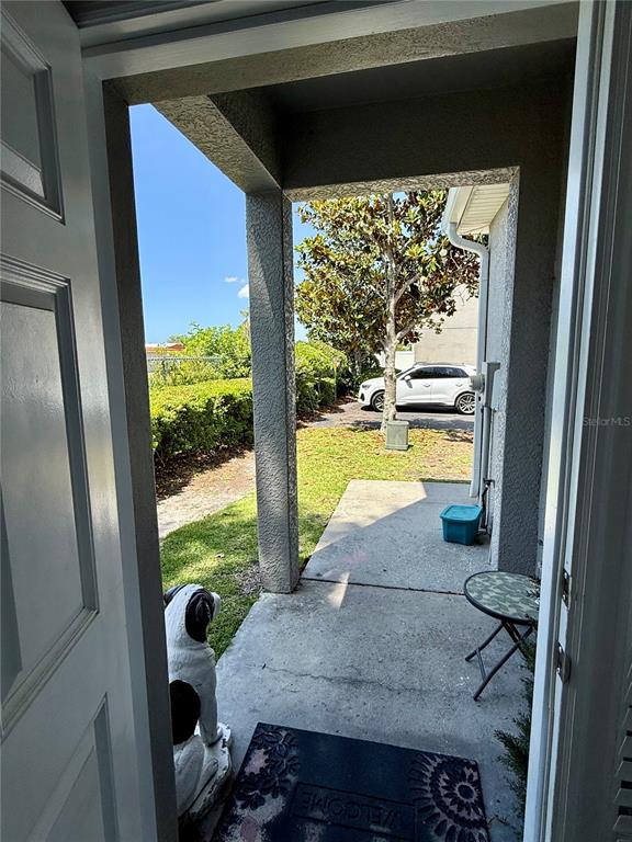 A two-story townhouse exterior features gray stucco, two garage doors, and a large magnolia tree — 13201 OPAL COURT, LARGO, FL