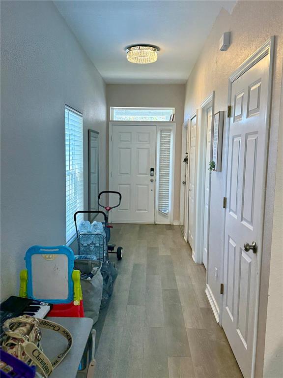 A view from an open doorway looking out onto a concrete patio and grassy yard — 13201 OPAL COURT, LARGO, FL