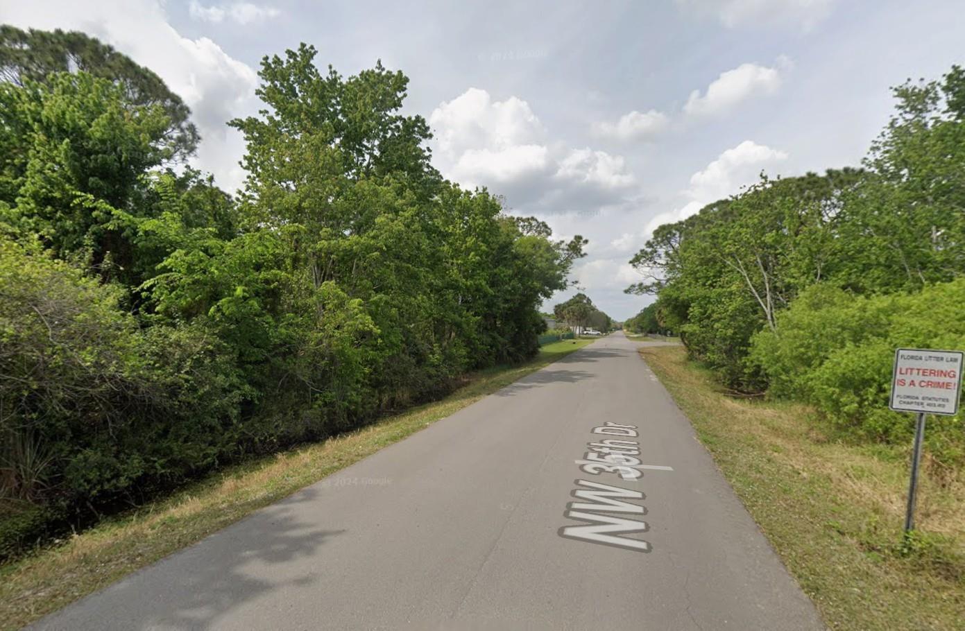 A paved road runs through a wooded area with a littering warning sign on the right — 2515 NW 35th Drive, Okeechobee FL 34972, OKEECHOBEE, FL