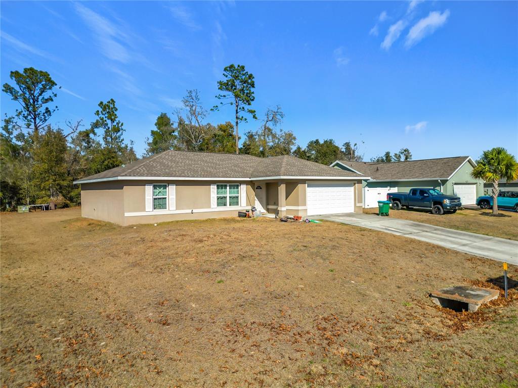 A single-story house with a tan exterior, white trim, and a two-car garage — 4263 SW 139TH PLACE, OCALA, FL