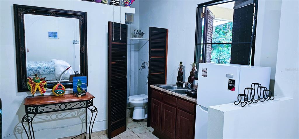 A small kitchenette area features a sink, a refrigerator, and an adjacent bathroom with a toilet — KM HM 0.2 ROAD 968, RIO GRANDE, PR