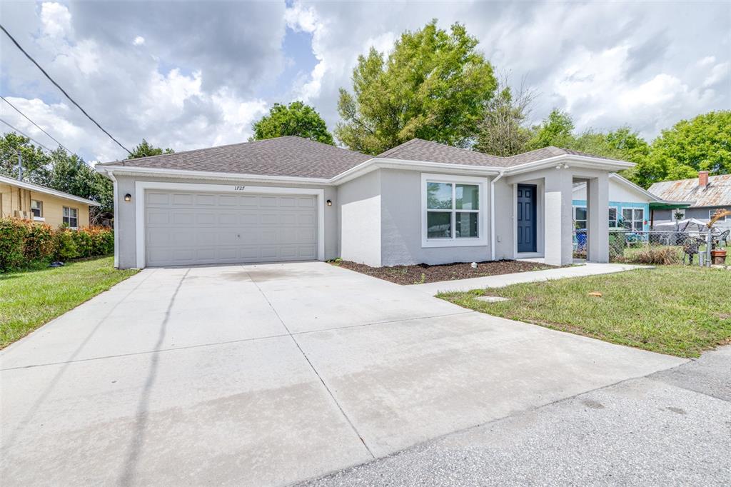 A single-story house with a gray exterior, a two-car garage, and a concrete driveway — 1727 SECOND STREET NE, WINTER HAVEN, FL