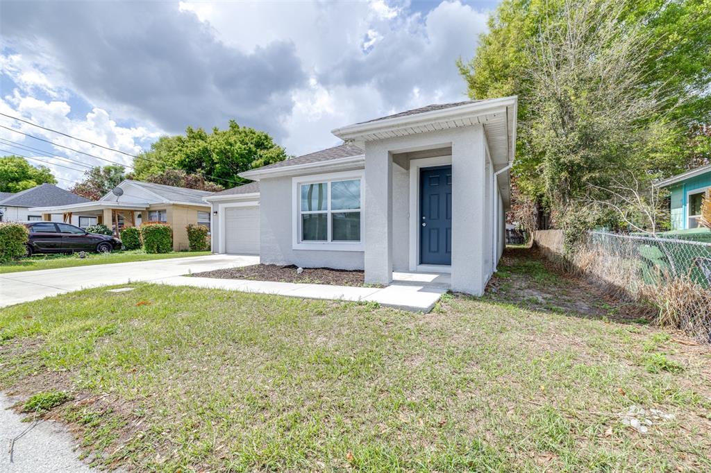 A single-story gray house with a dark blue front door and an attached garage — 1727 SECOND STREET NE, WINTER HAVEN, FL