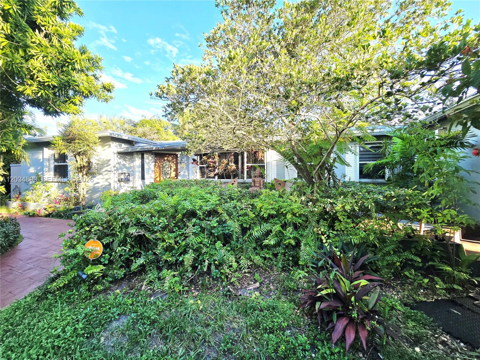 A single-story house with a front garden, a paved walkway, and a wooden front door — 2630 Monroe St, Hollywood FL 33020, HOLLYWOOD, FL