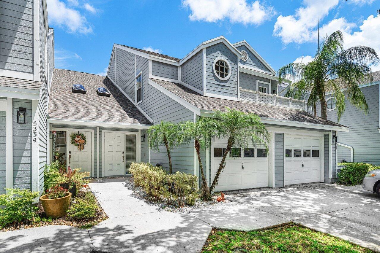 A two-story gray house with two garage doors, a front walkway, and palm trees — 5336 Buckhead Circle # 2020, Boca Raton FL 33486, BOCA RATON, FL