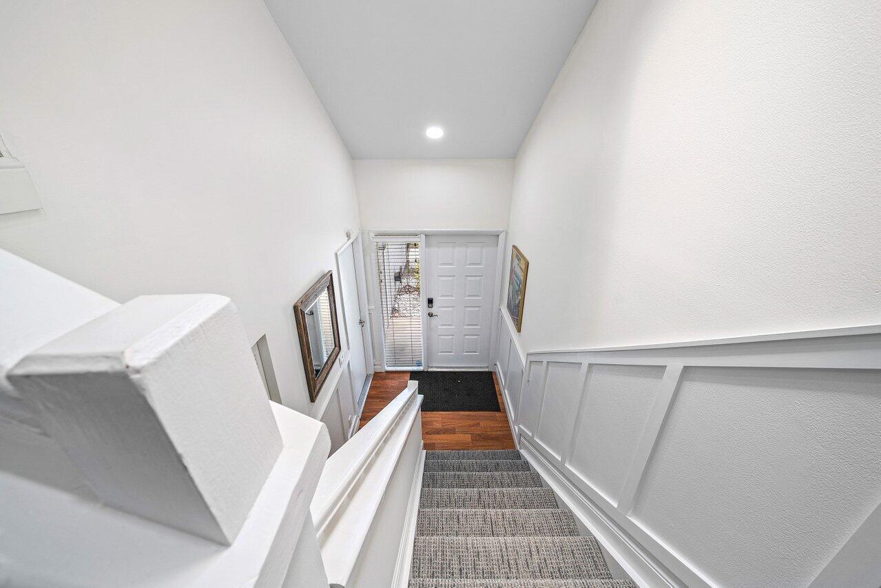 A high-angle view shows a carpeted staircase leading down to a white front entryway — 5336 Buckhead Circle # 2020, Boca Raton FL 33486, BOCA RATON, FL