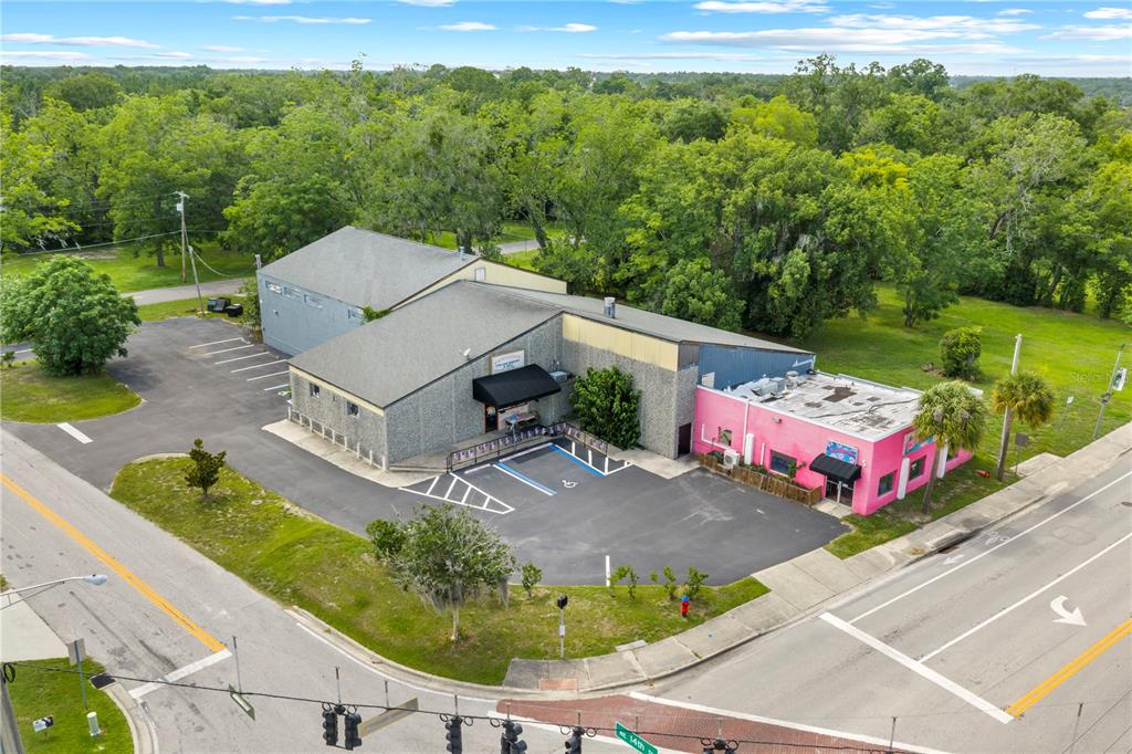 An aerial view shows a commercial building with a gray section and a pink section — 1412 N MAGNOLIA AVENUE, OCALA, FL