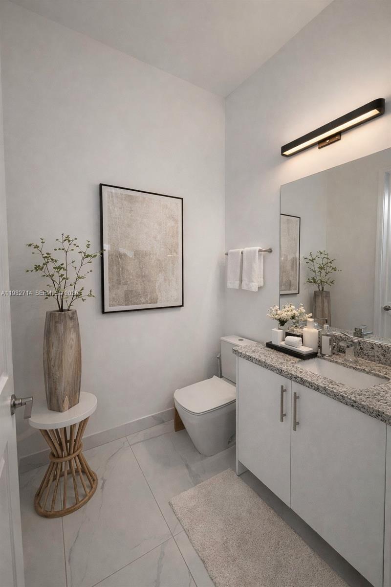 A modern powder room features a white vanity, granite countertop, and a tall wooden vase — 22255 SW 132nd Ave, Miami FL 33170, MIAMI, FL