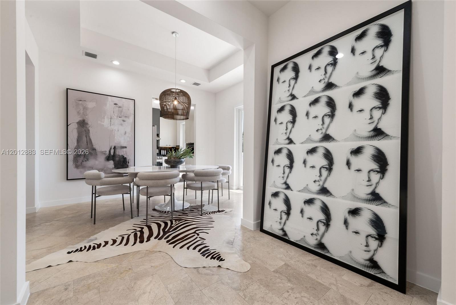 A dining area features a zebra-print rug, a round table, and a large portrait art piece — 349 Madeira Ave # 349, Coral Gables FL 33134, CORAL GABLES, FL