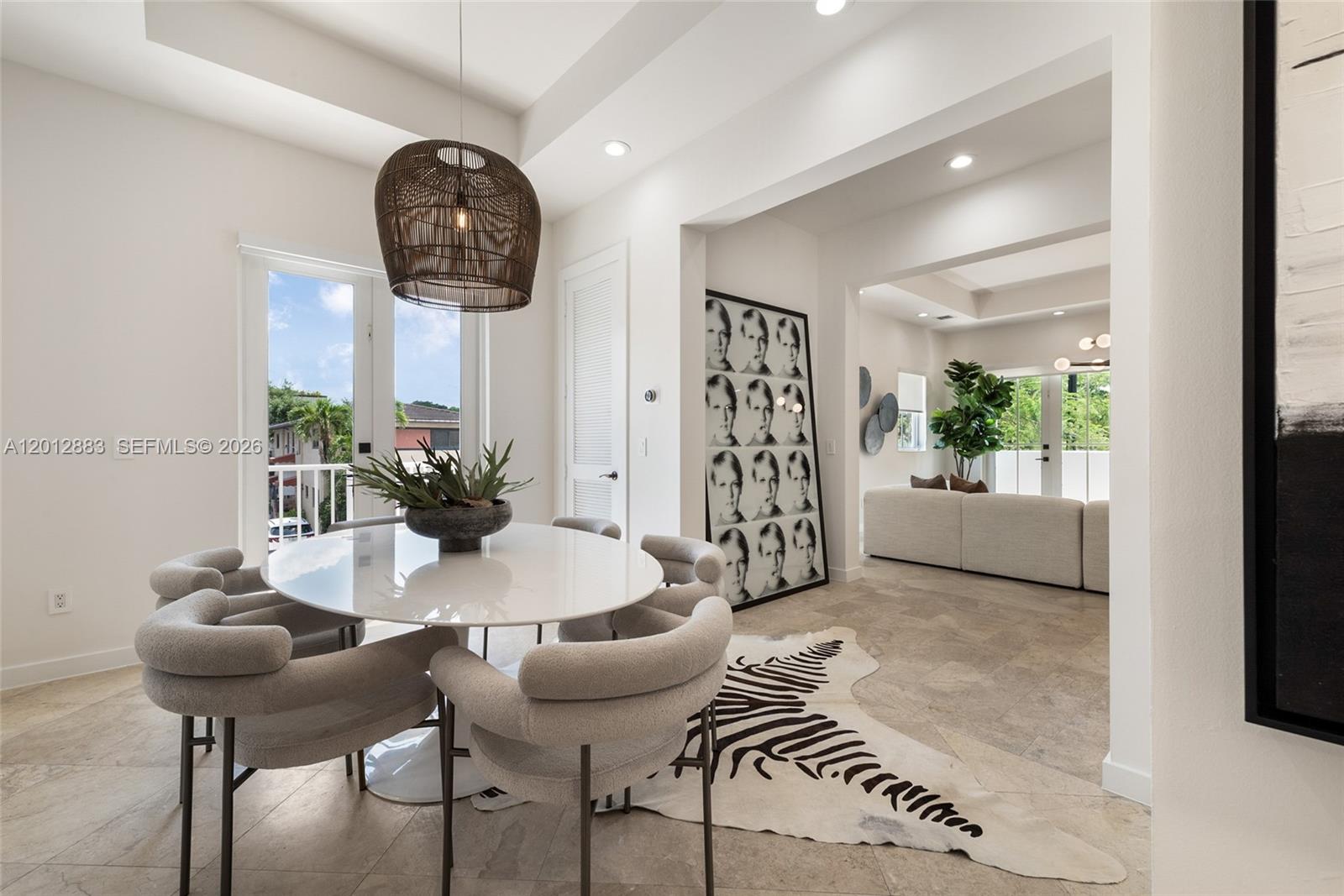 A dining area with a round table and chairs sits adjacent to a living room — 349 Madeira Ave # 349, Coral Gables FL 33134, CORAL GABLES, FL