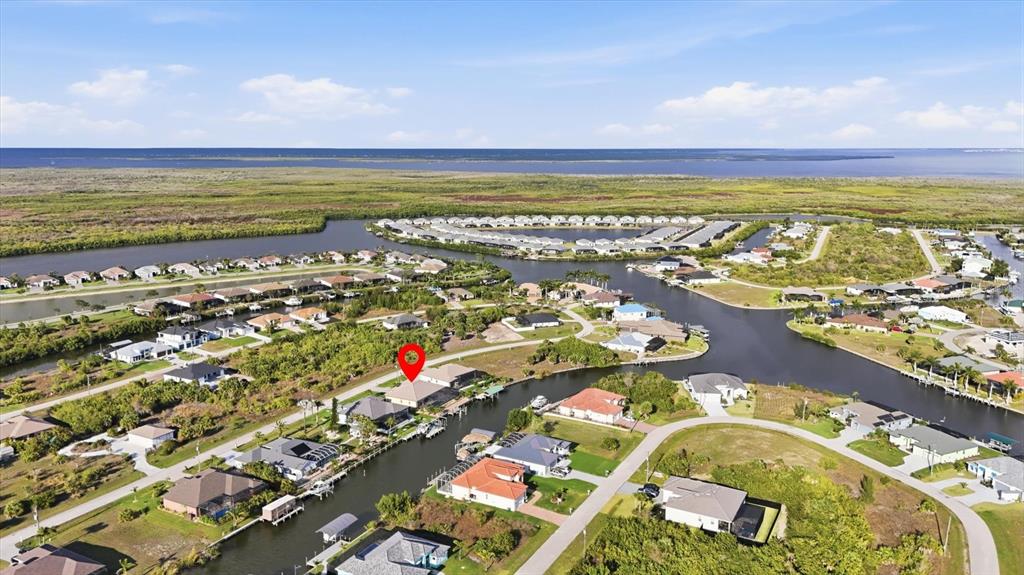 An aerial view shows a residential neighborhood with houses situated along a canal — 15260 LEIPZIG CIRCLE, PORT CHARLOTTE, FL