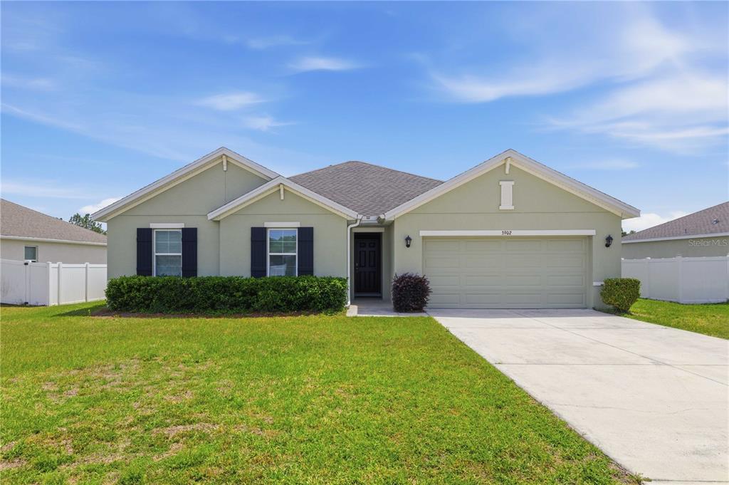 A single-story house with a light green exterior, a two-car garage, and black shutters — 3902 SE 99TH STREET, BELLEVIEW, FL