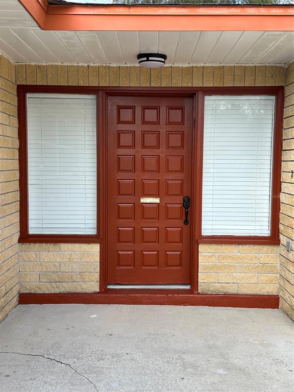 A front entrance features a red paneled door flanked by two windows with white blinds — 470 LAKE ROAD, OCALA, FL