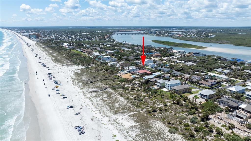 An aerial view shows a beach house marked by a red arrow near the ocean — 1413 N ATLANTIC AVENUE, NEW SMYRNA BEACH, FL