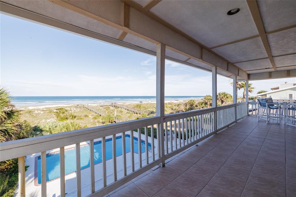 A covered balcony overlooks a swimming pool, sand dunes, and the ocean — 1413 N ATLANTIC AVENUE, NEW SMYRNA BEACH, FL