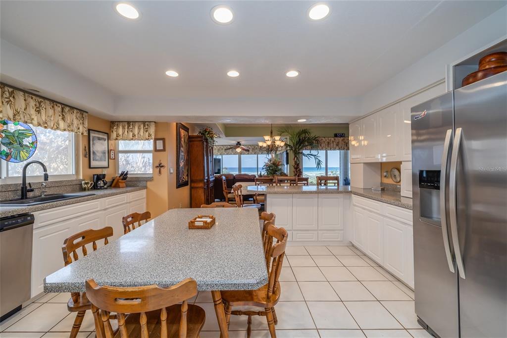 A kitchen with white cabinets, a granite island, and a view of the ocean — 1413 N ATLANTIC AVENUE, NEW SMYRNA BEACH, FL