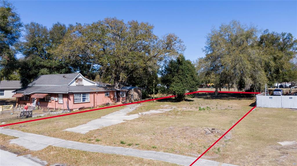 An aerial view shows a vacant, grassy residential lot outlined in red next to a house — 155 MA BOARD STREET, APOPKA, FL
