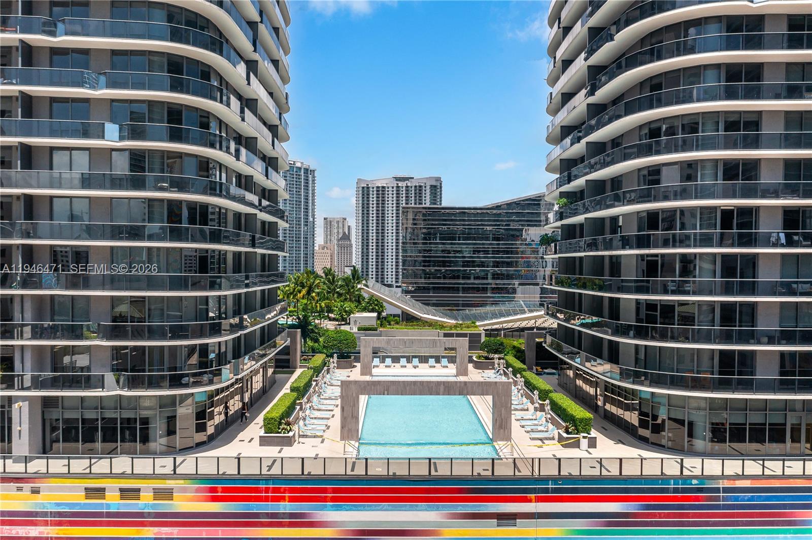 An outdoor swimming pool is situated between two modern high-rise apartment buildings — 45 SW 9th St # 1205, Miami FL 33130, MIAMI, FL