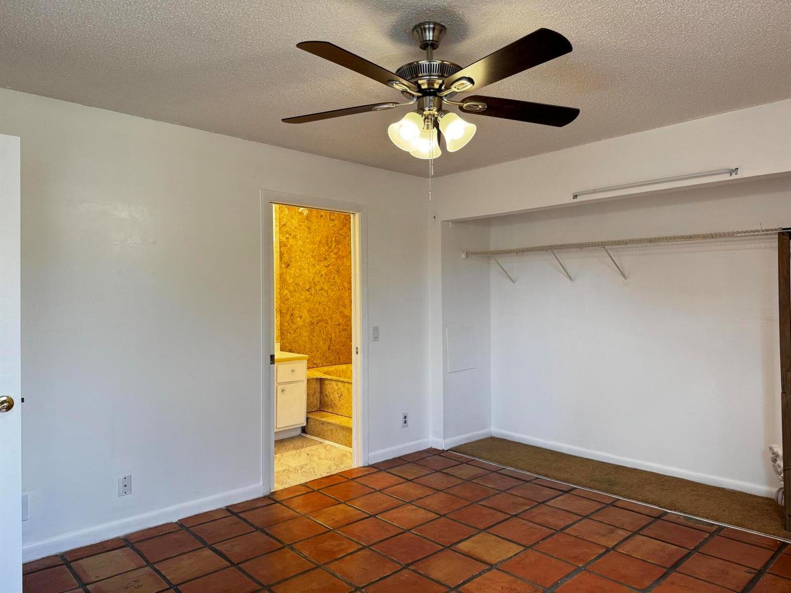 A room with terracotta tile flooring, a ceiling fan, and an open closet area — 24 Crossings Circle # H, Boynton Beach FL 33435, BOYNTON BEACH, FL