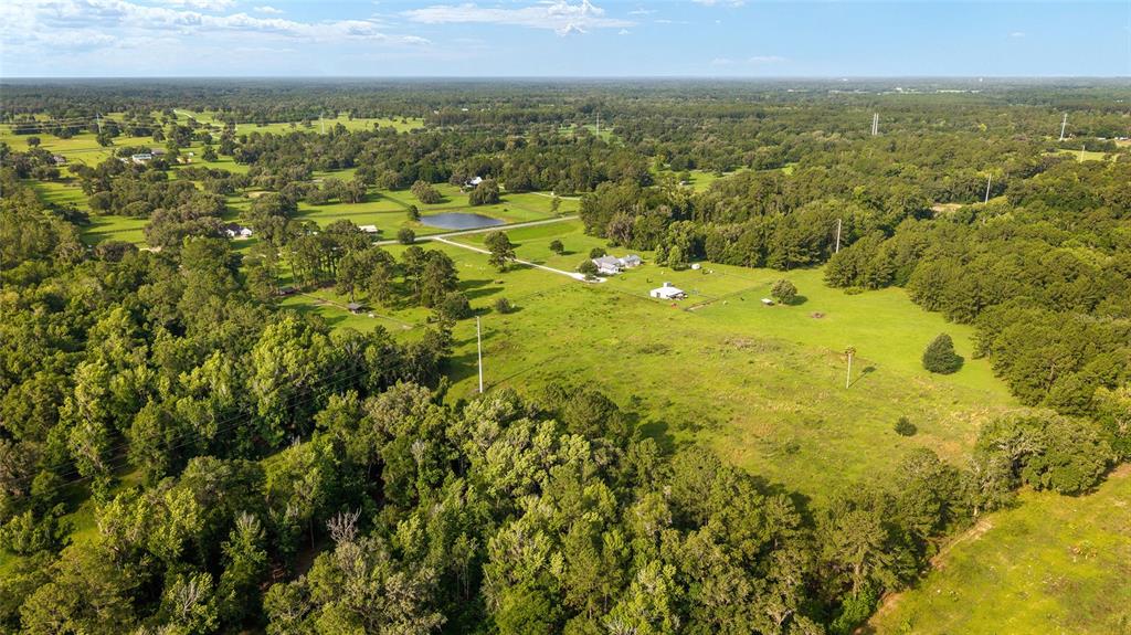 An aerial view shows a rural property with a house, outbuildings, a pond, and trees — 15015 NW 185TH STREET, WILLISTON, FL