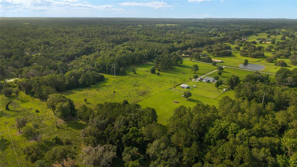 An aerial view shows a rural property with a house, outbuildings, and a small pond — 15015 NW 185TH STREET, WILLISTON, FL