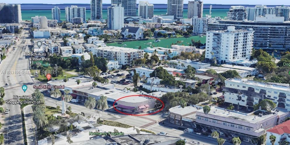 An aerial view shows a commercial building with a red-circled storefront near a public fountain — 940 71st St, Miami Beach FL 33141, MIAMI BEACH, FL