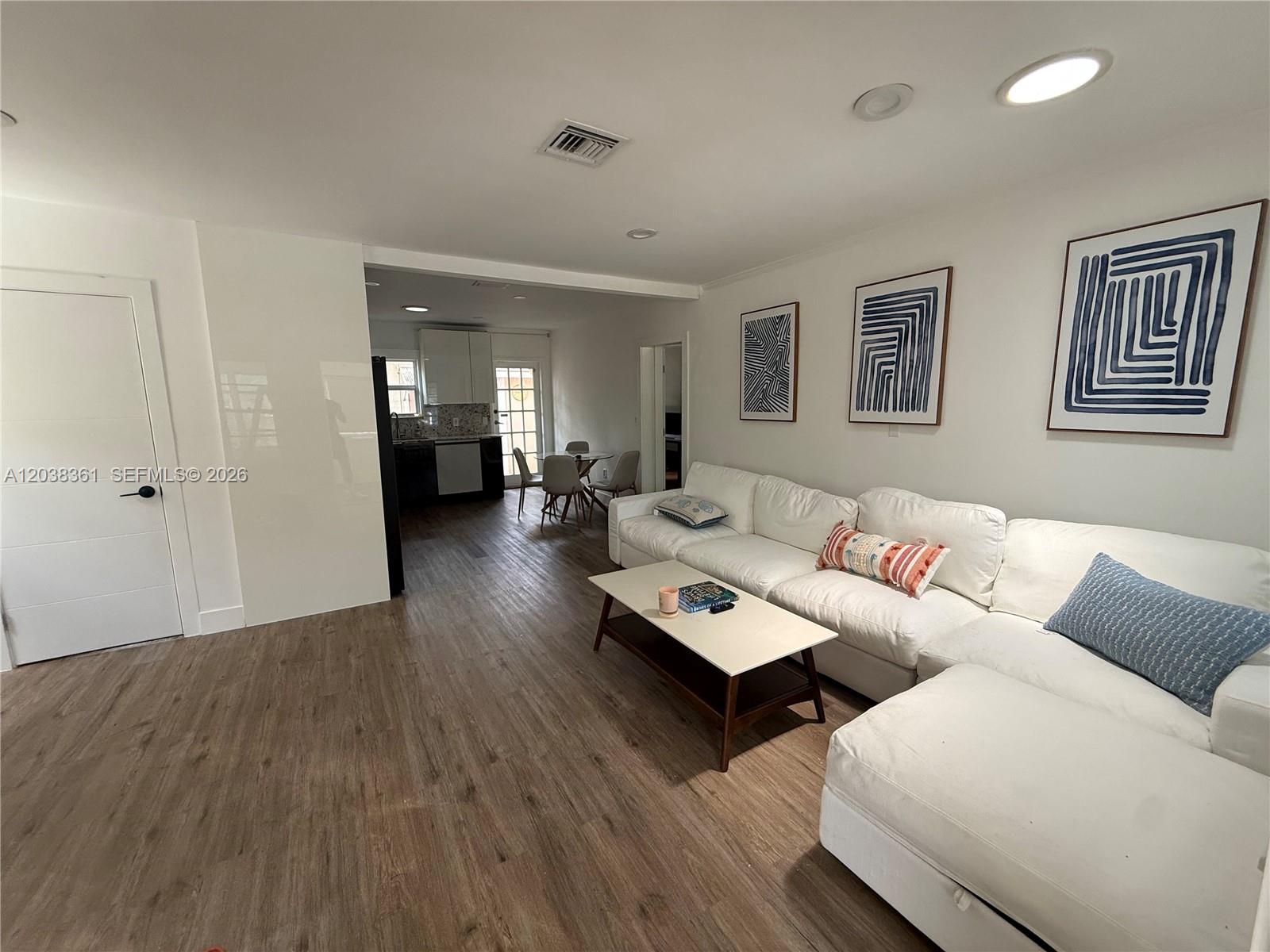 A living room with a white sectional sofa leads into a kitchen and dining area — 1719 Hayes St, Hollywood FL 33020, HOLLYWOOD, FL