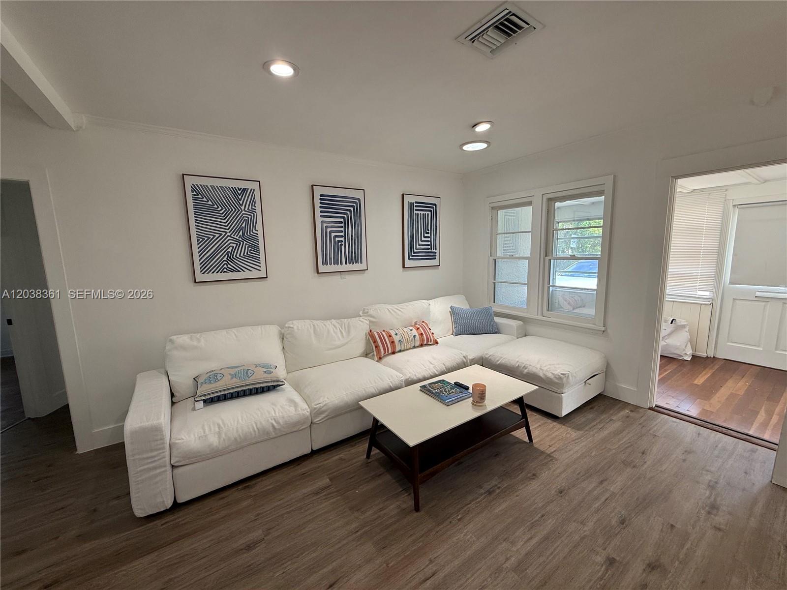 A living room features a white sectional sofa, a coffee table, and three framed prints — 1719 Hayes St, Hollywood FL 33020, HOLLYWOOD, FL