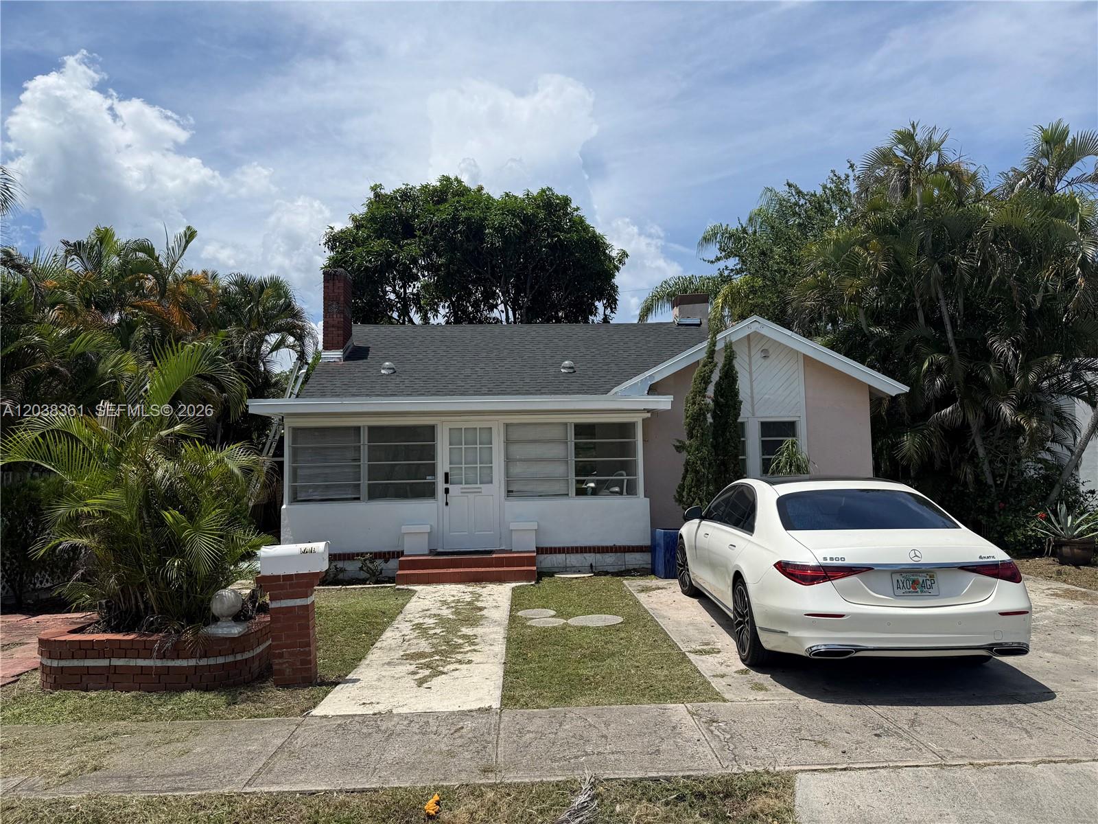 A bedroom features white walls, hardwood floors, a dark wardrobe, and a white bed — 1719 Hayes St, Hollywood FL 33020, HOLLYWOOD, FL