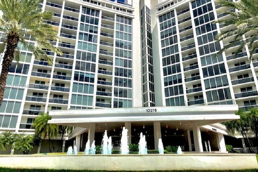 A tall white apartment building features a prominent entrance with a multi-tiered water fountain — 10275 Collins Ave # 634, Bal Harbour FL 33154, BAL HARBOUR, FL