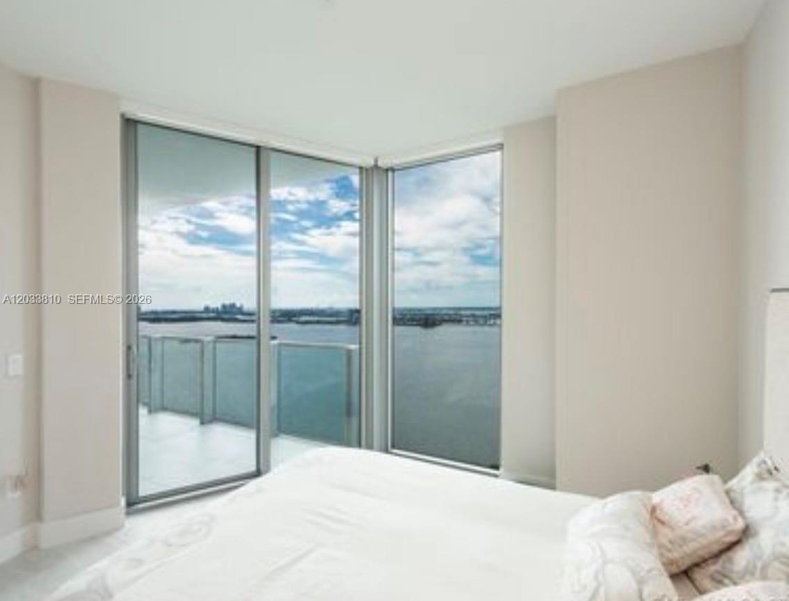 A bedroom features floor-to-ceiling windows with a view of the water and a balcony — 2900 NE 7th Ave # 2908, Miami FL 33137, MIAMI, FL