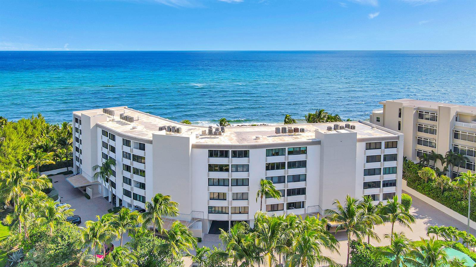 An aerial view of a multi-story white apartment building located directly on the oceanfront — 6885 N Ocean Boulevard # 3040, Ocean Ridge FL 33435, OCEAN RIDGE, FL