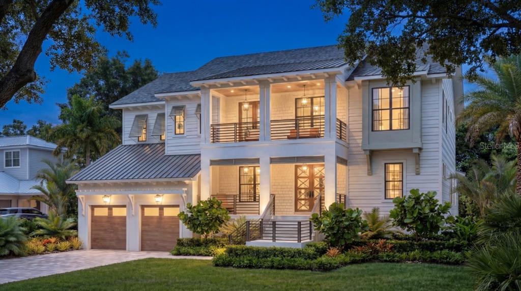 A two-story white house with a metal roof, double garage, and two-level front porch — 618 LUZON AVENUE, TAMPA, FL